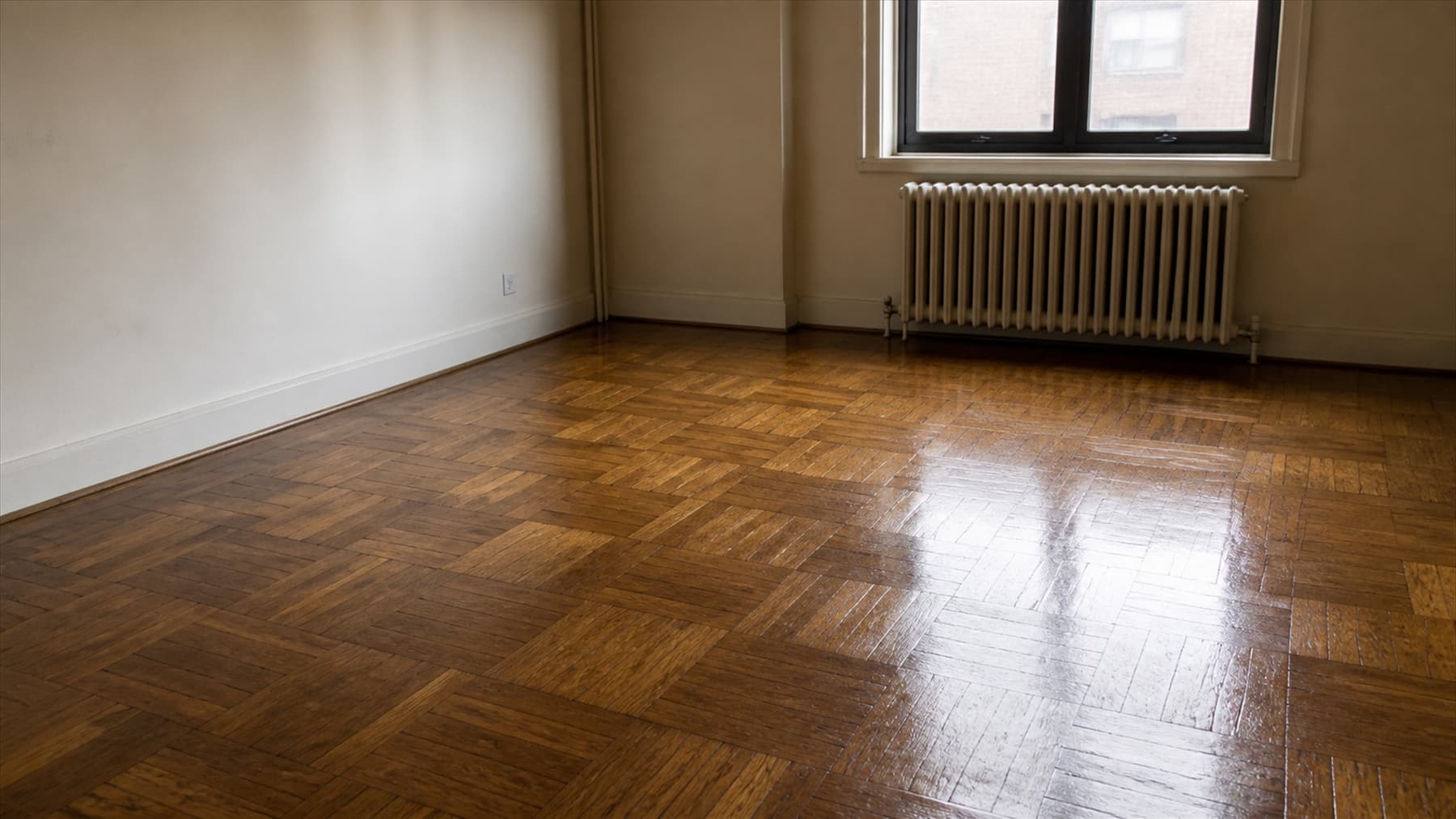 An older oak parquet floor after a fresh coat, the surface even and softly reflective